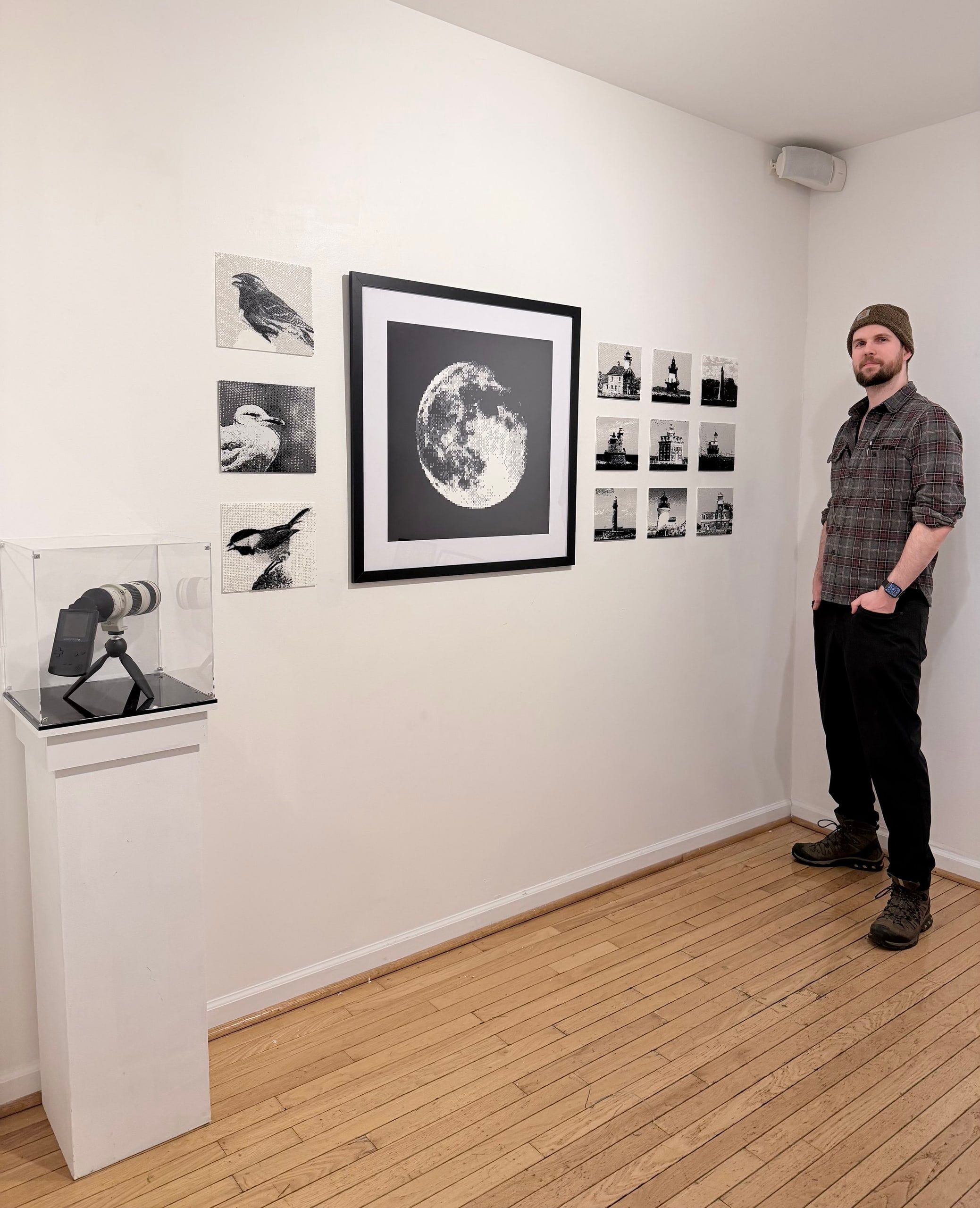 Bastiaan next to his Game Boy Camera prints on a gallery wall